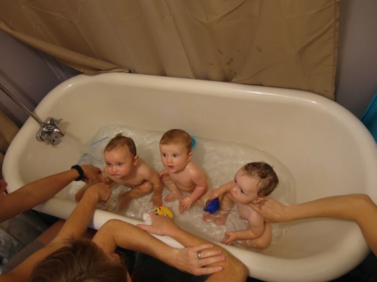 a family plays with each other in a tub filled with bubbles
