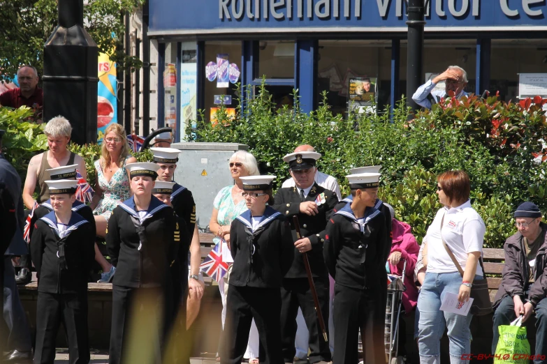 some navy men and women stand in the street