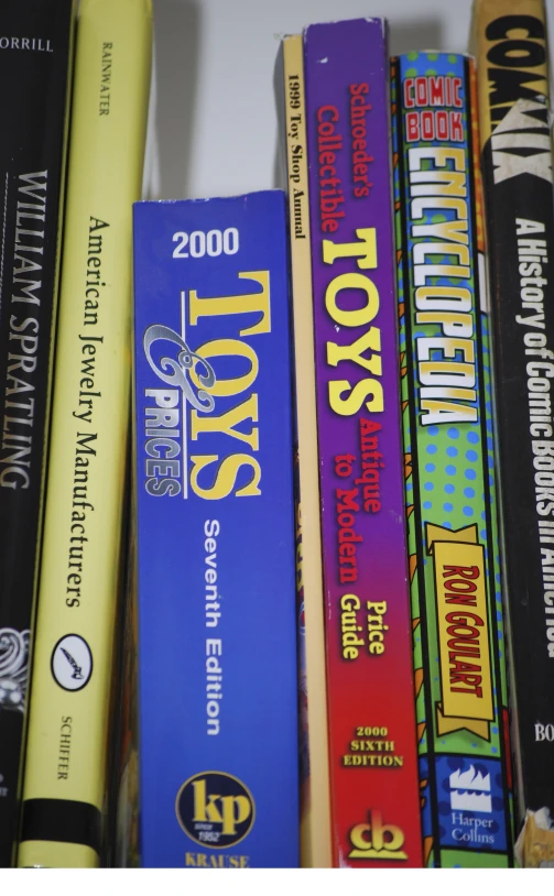 several books on a white shelf that includes various kinds of items