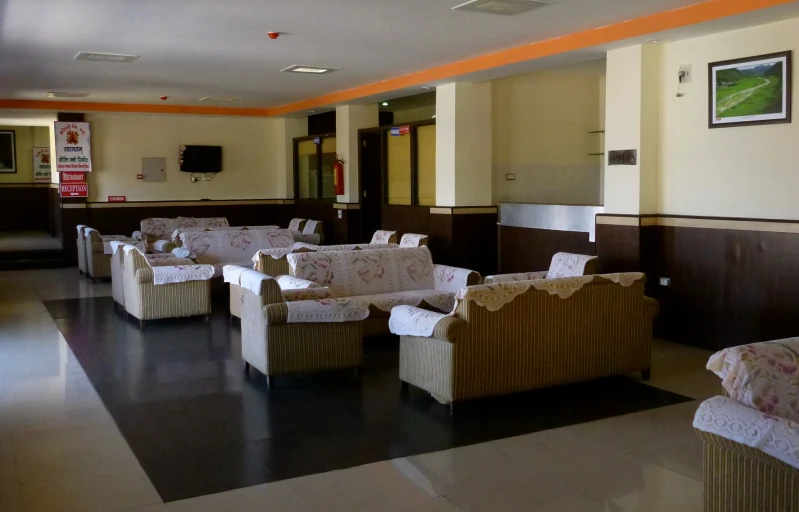 a large room with white chairs and beige decor