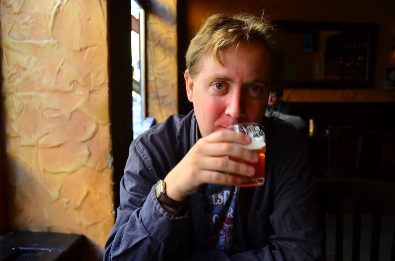 the man is drinking beer in the bar