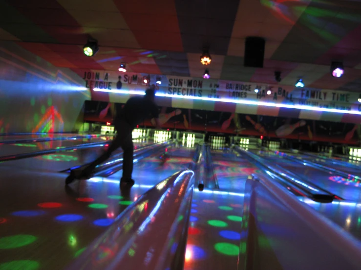 the lights in a bowling alley are colored red, white, blue, and green