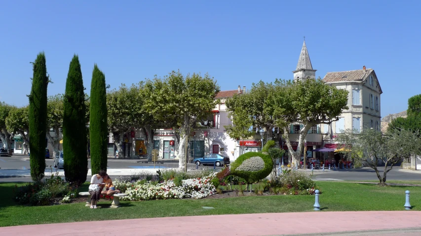 a garden filled with trees next to a parking lot