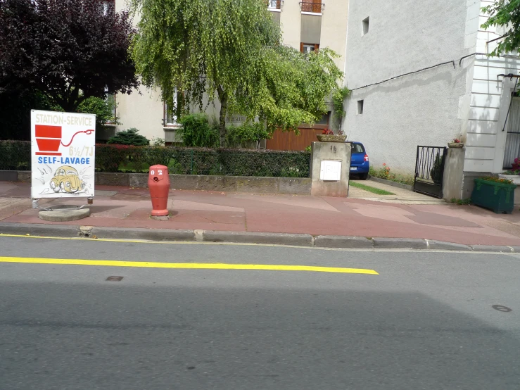 a red fire hydrant sitting on the side of a road