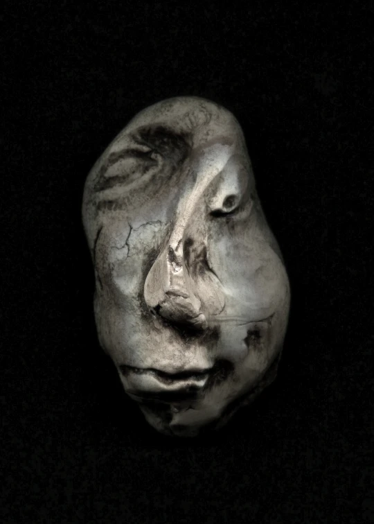 an artisticly carved face is featured in this black and white po