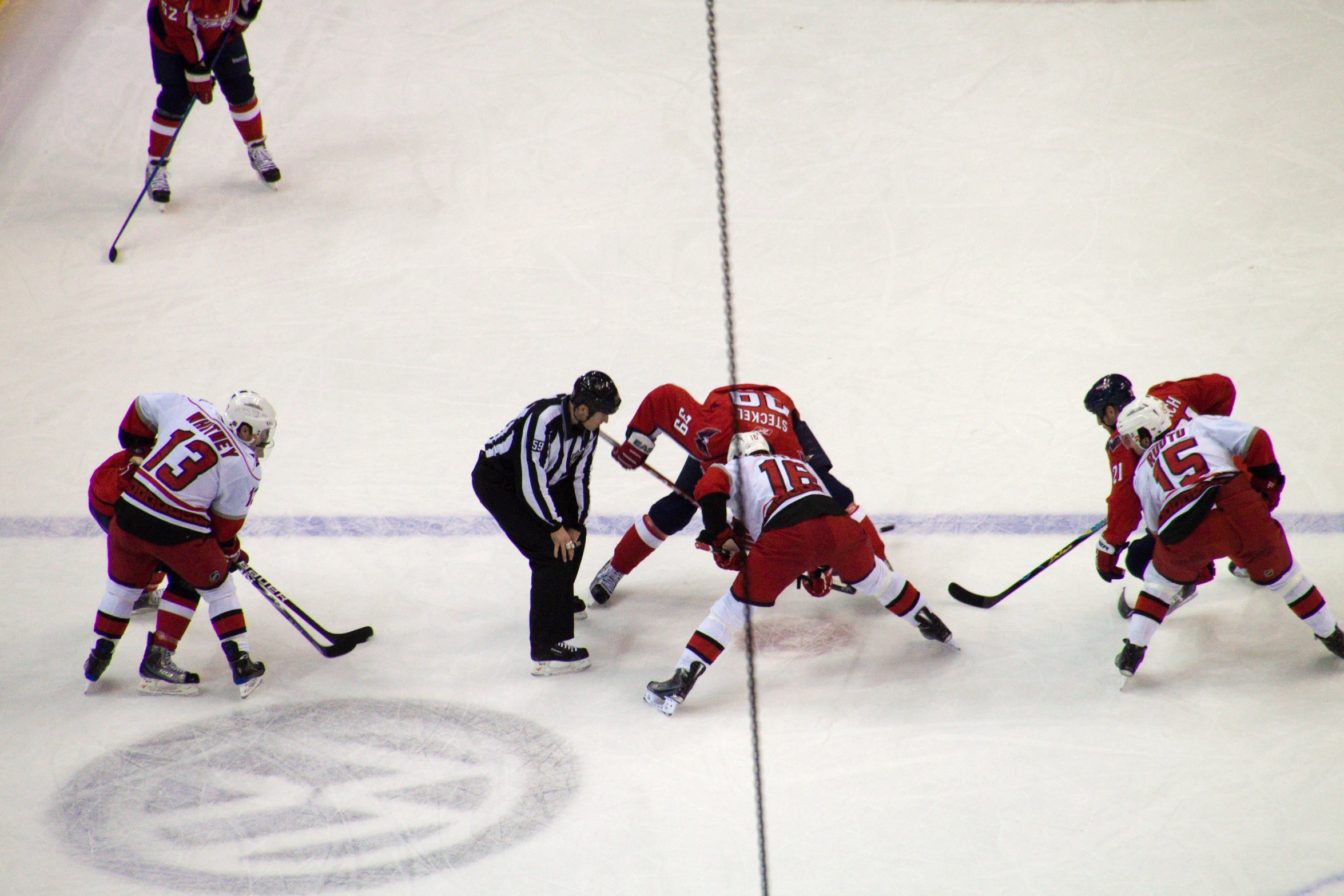 an overhead view of an arena showing a hockey team competing