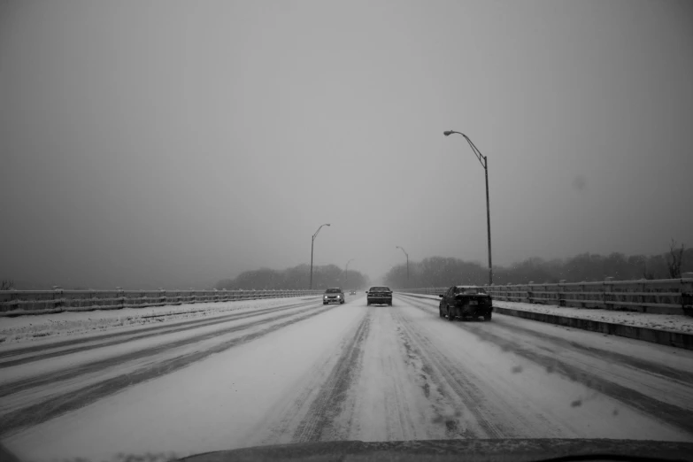 two trucks driving down a snowy road on a freeway