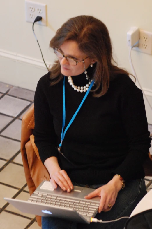 a woman sitting on a chair working on a laptop