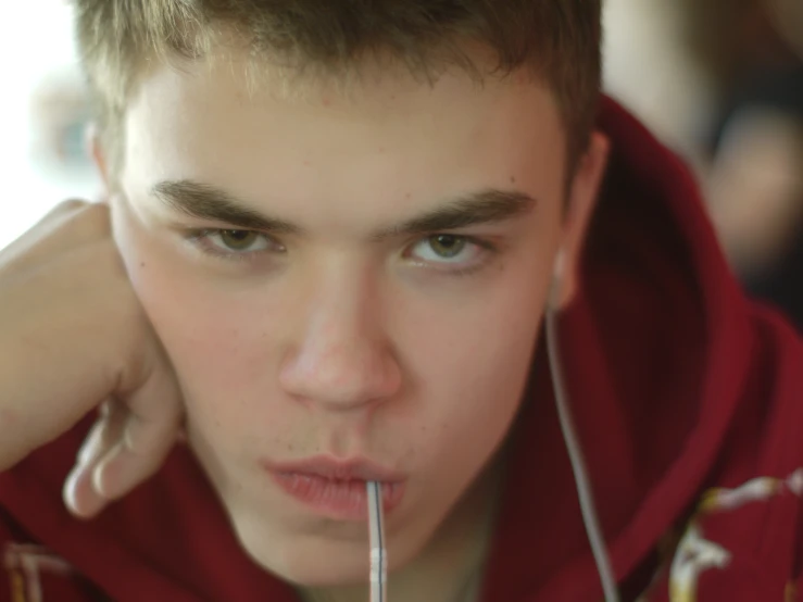 a young man is putting a toothbrush in his mouth