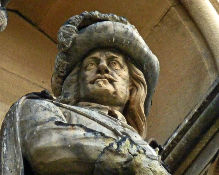 a statue is seen holding a hat on top of its head