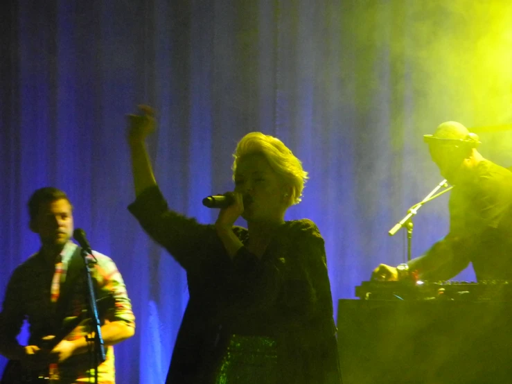 two people on a stage singing into a microphone