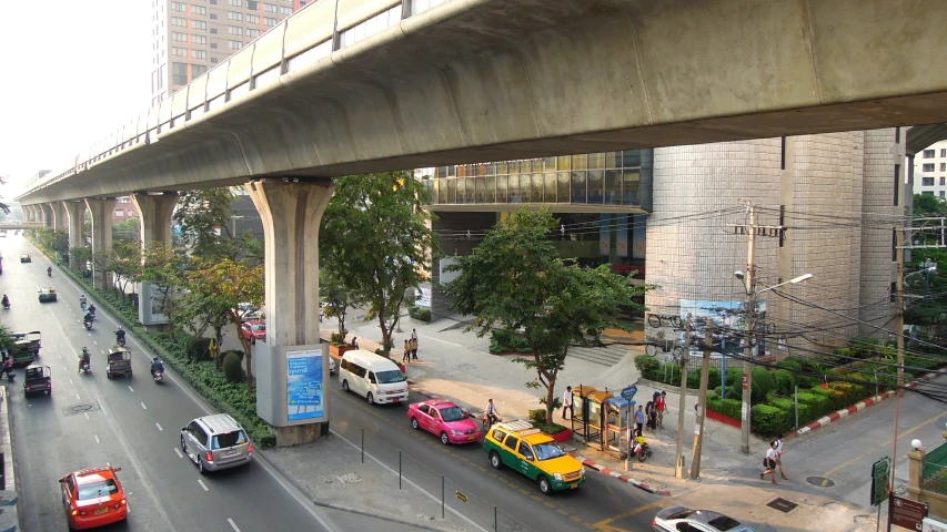 cars driving down a city street under a bridge