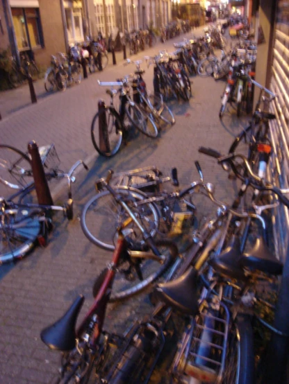 several bicycles parked on the street together with people