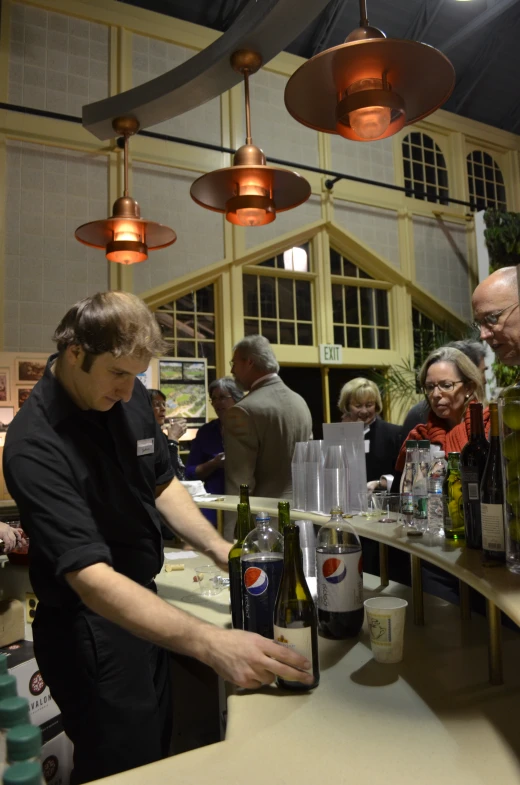 a group of people at a bar that is filled with bottles of wine