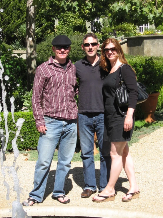 two adults standing near one another with water spouting behind them