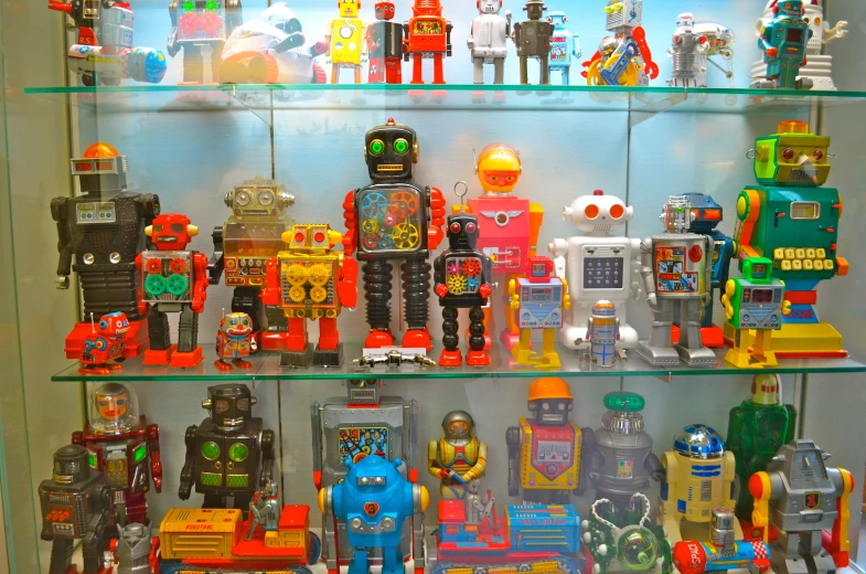 many robot toys are sitting on shelves, all lined up