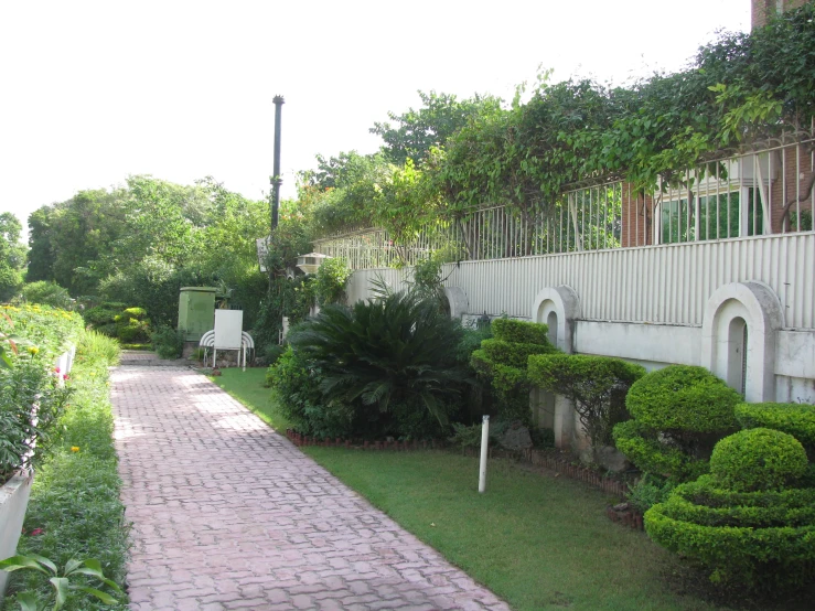 a walkway is shown between some bushes and an apartment building