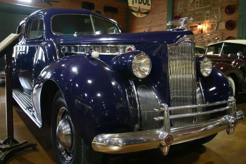 an old classic car in a museum with other cars