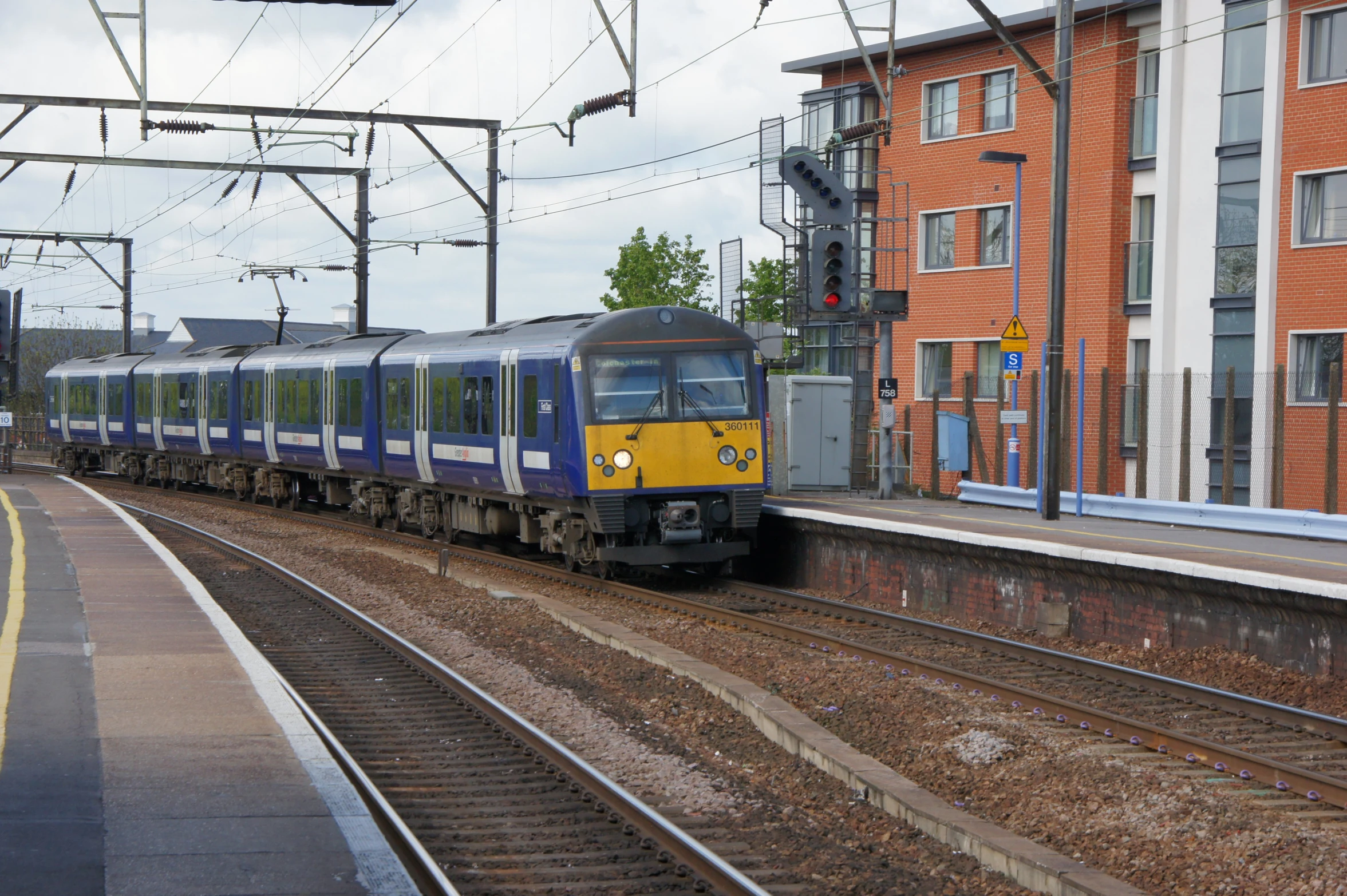 a train traveling down tracks past tall buildings