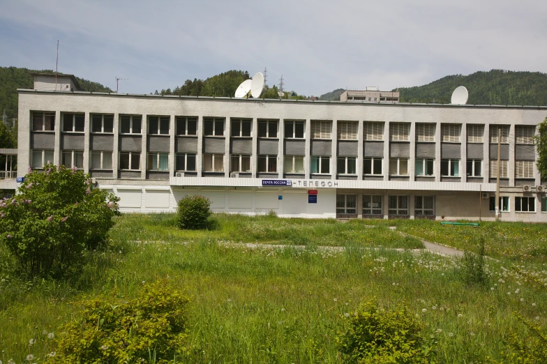 a large building on top of green hills