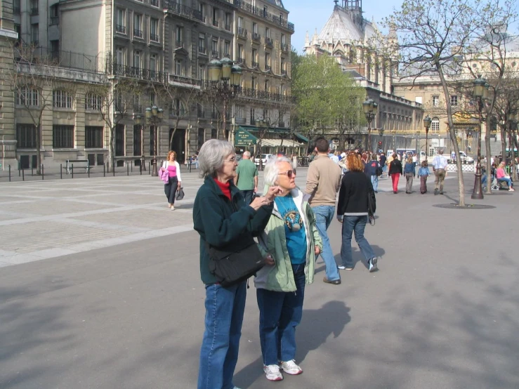 two women standing in the middle of an empty plaza