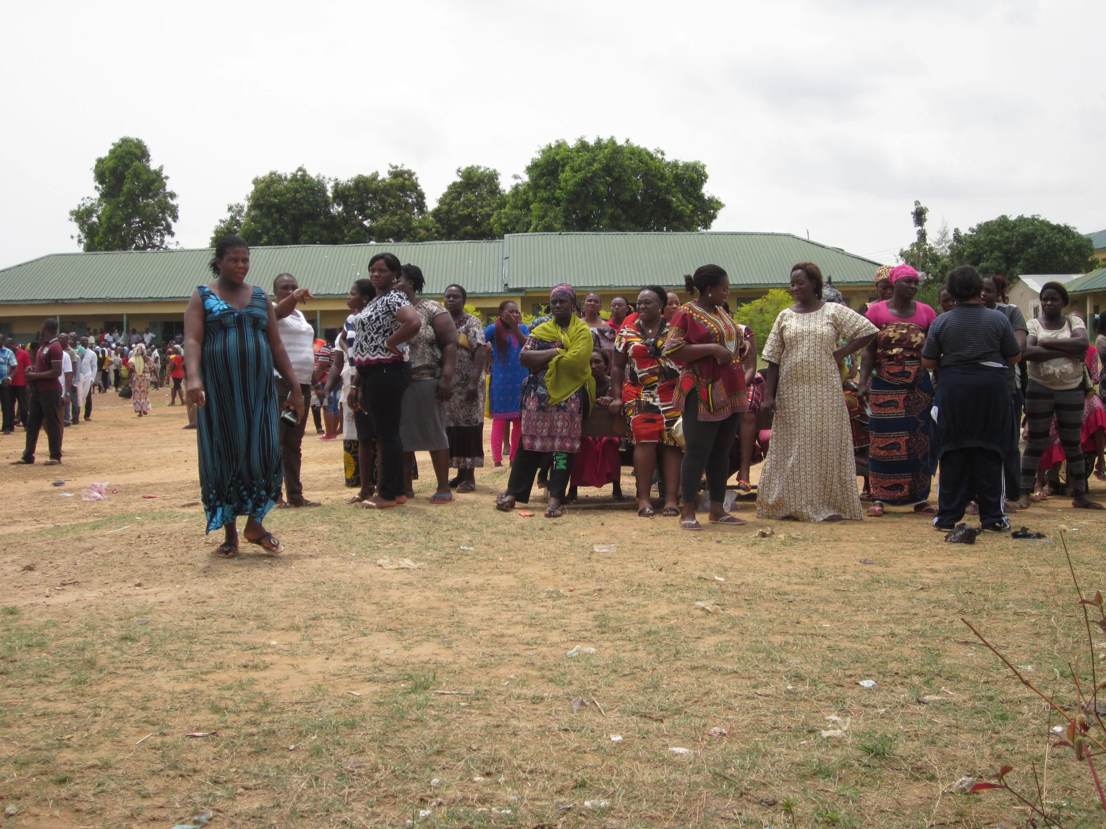 many people standing around with umbrellas and other items