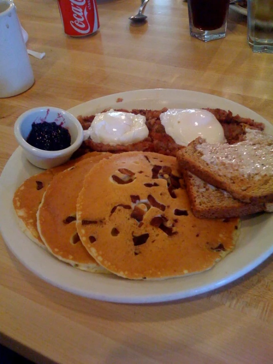 breakfast plate full of pancakes and eggs on a table