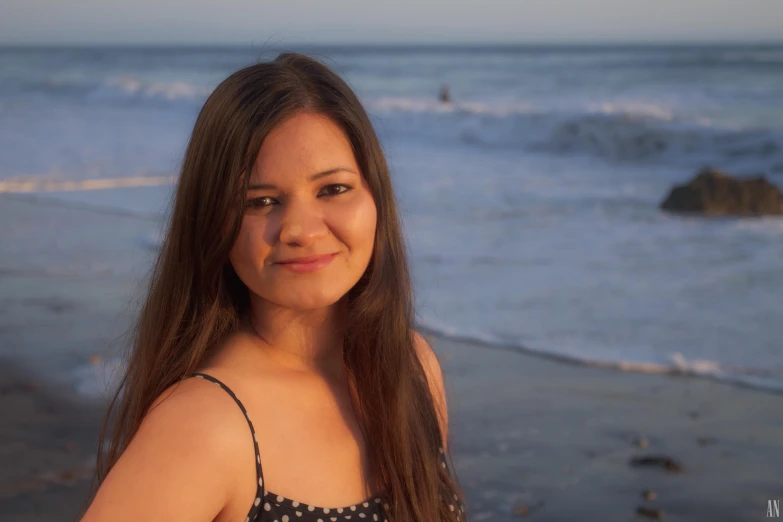 a woman with long hair standing on the beach