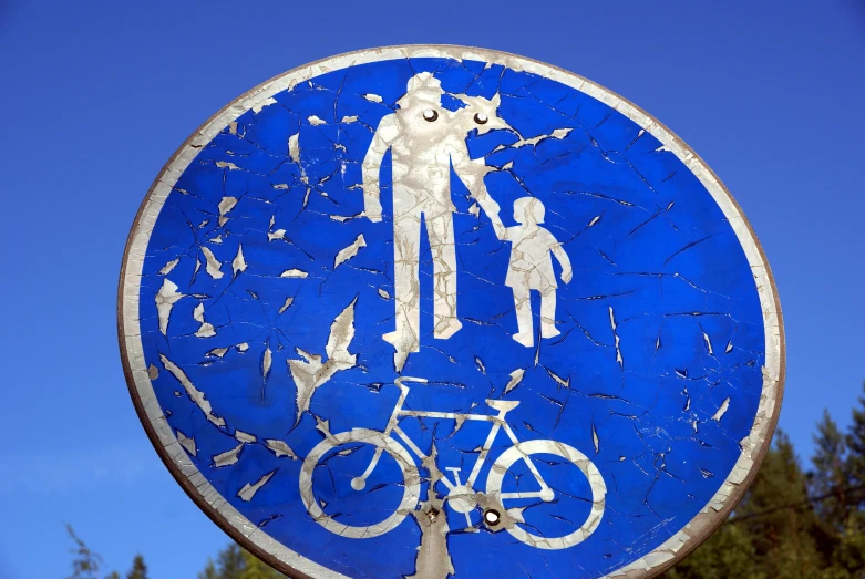 a sign on the road with an image of a woman holding hands with a man and child