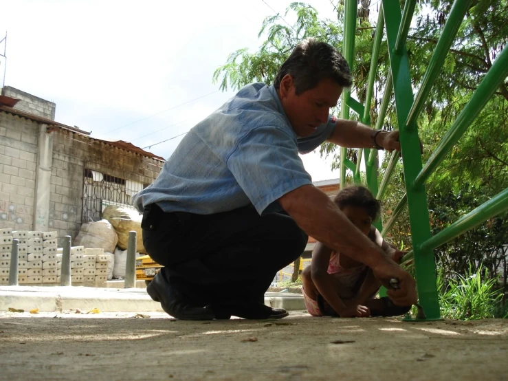 two men work on a plant outside