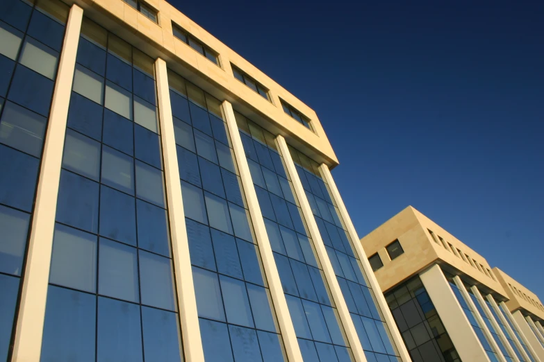 windows on a large building with the sky behind them