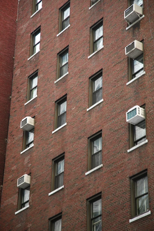 large red brick building with multiple windows with a sign in the middle