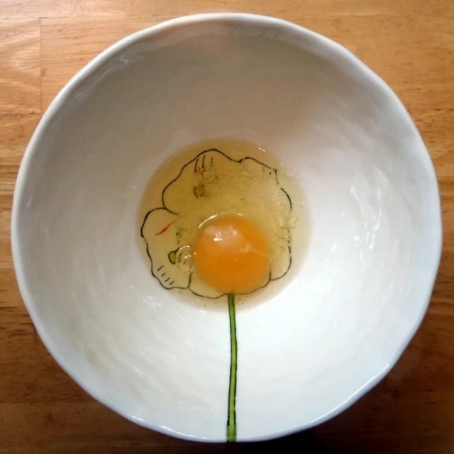 a white bowl has an egg with the end cut out