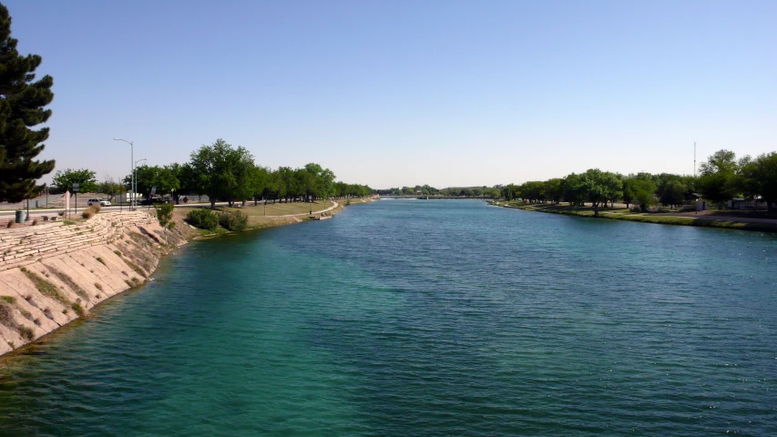 a long stretch of water sits in the foreground with a sandy bank next to it