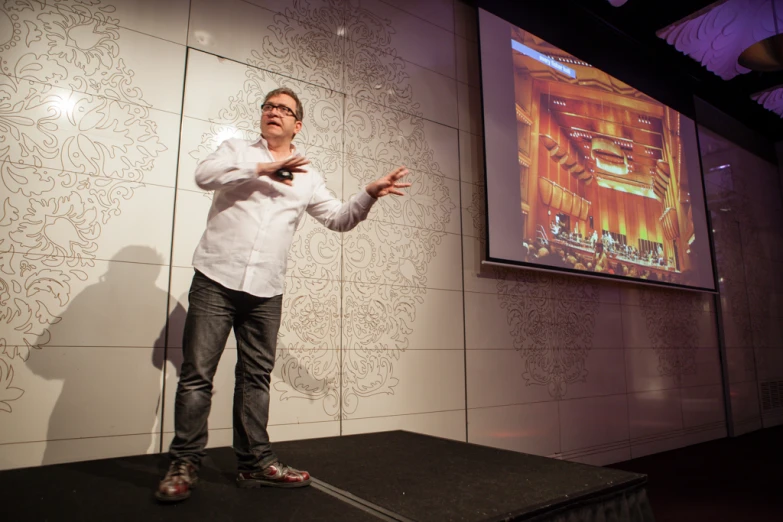 a man standing on a stage holding a smart phone