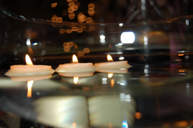 a group of candles sitting inside of a glass vase