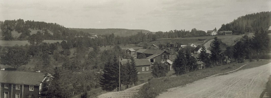 old pograph of a country road leading down to some houses