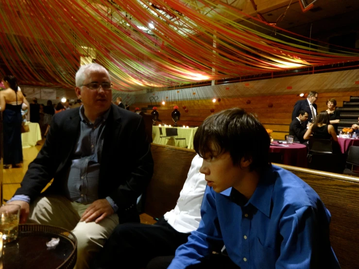 a couple of men sitting down at a dinner table