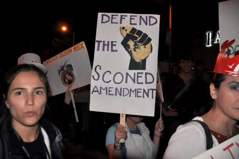 protestors hold up signs during the march 24 rally