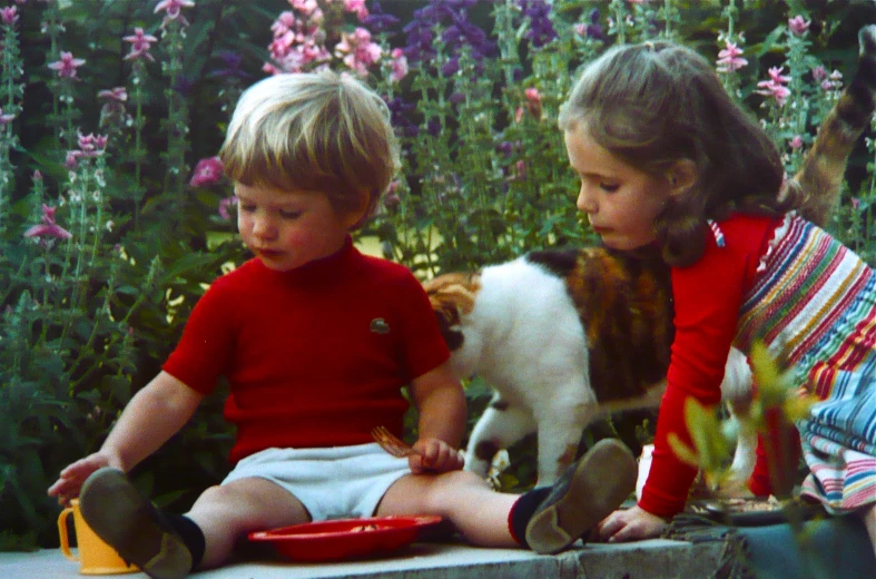 two children with one playing on a bench, the other eating