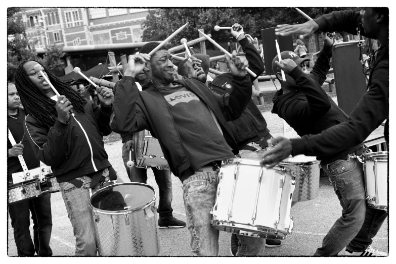 drummers are carrying drums together as they perform