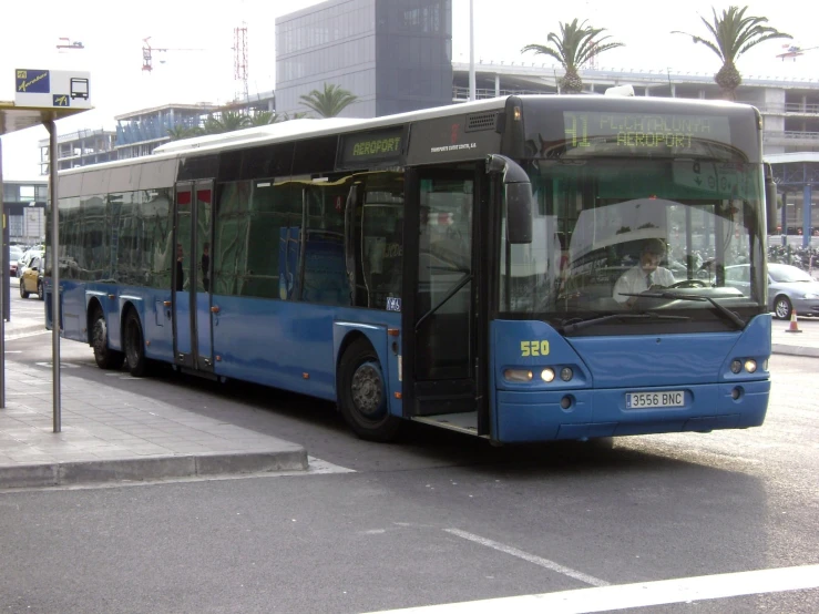 a large blue city bus parked next to a street