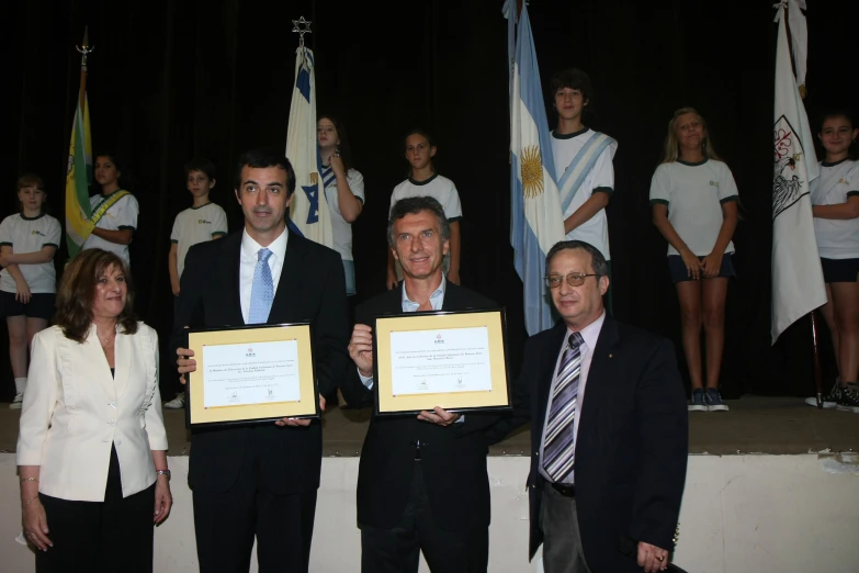 three men and two women holding up papers