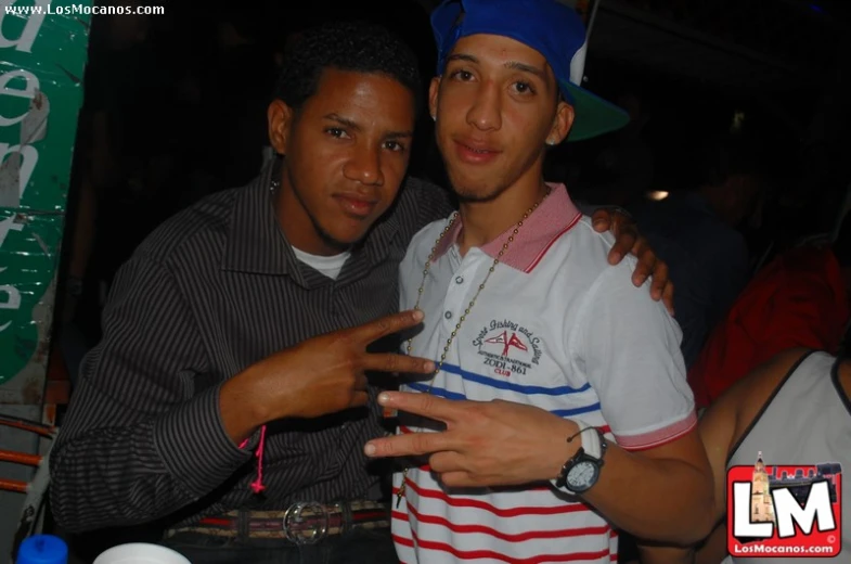 two young men standing next to each other at a party