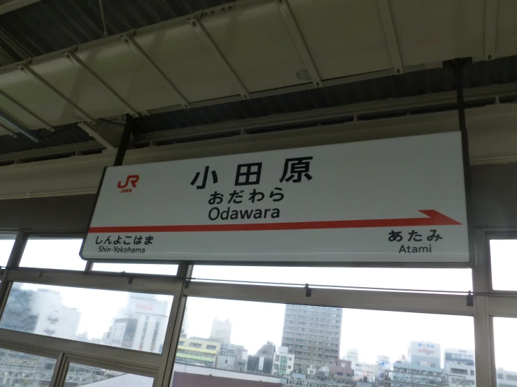 a sign with asian writing near a window in the train station