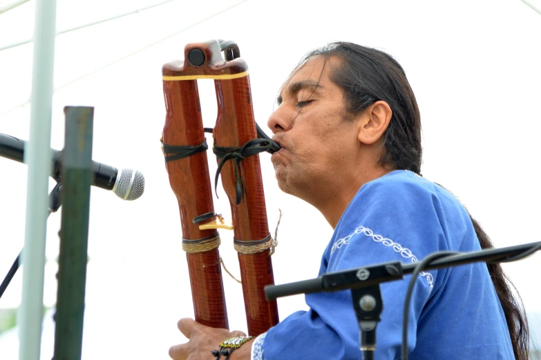 a man is playing a wooden instrument on stage