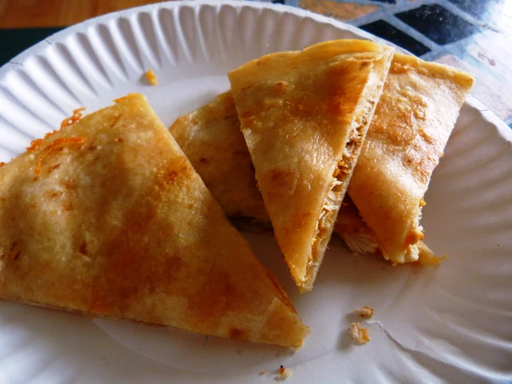 three pieces of empanadas are on a paper plate