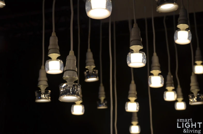 many light bulbs are suspended above an open room
