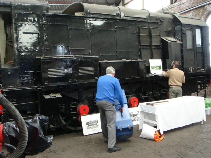 men are loading up boxes to board an old locomotive