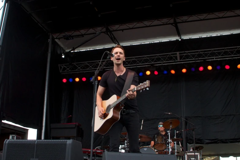 a man with an acoustic guitar on stage